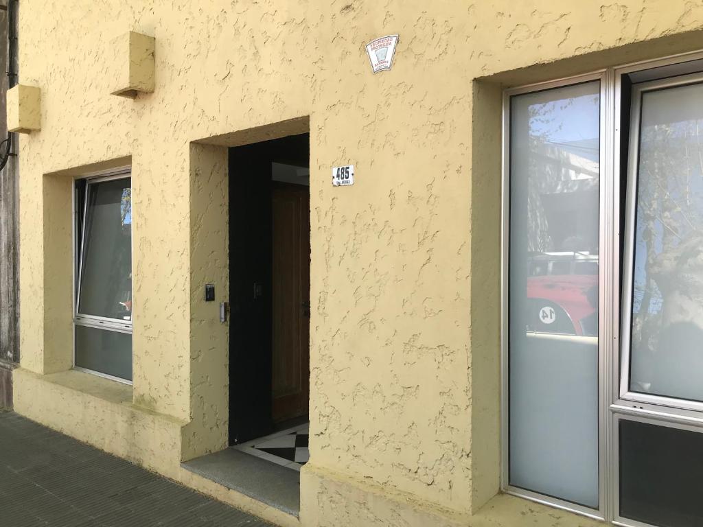 Una puerta a un edificio con ventanas. en Suite Artigas, en Colonia del Sacramento