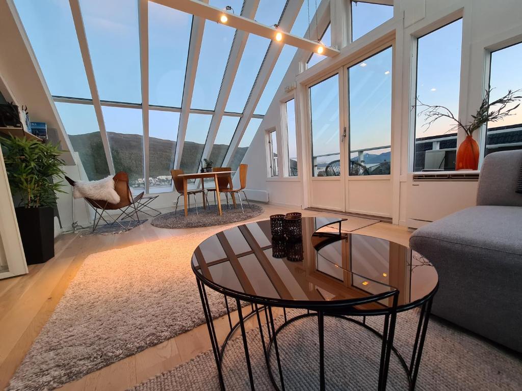 a living room with a couch and a table at Glass roof private loft in Tromsø in Tromsø