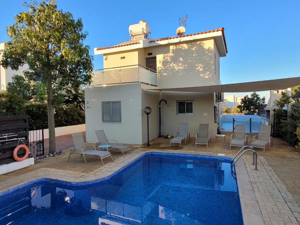 a villa with a swimming pool and a house at Poros 2 Villa in Protaras