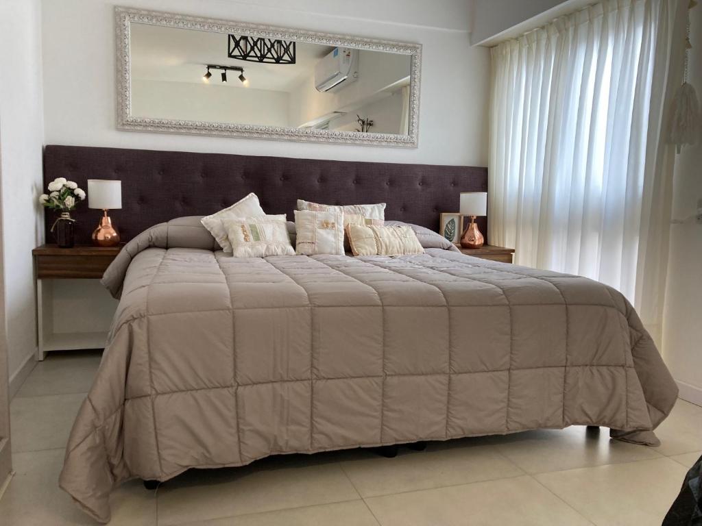 a bedroom with a large bed with a large mirror at 1353 Amplió y luminoso in Mar del Plata