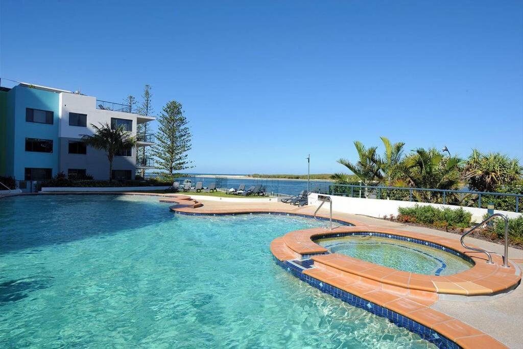 a swimming pool in a resort next to a building at Prime Position – Dream Holiday Unit in Caloundra!! in Caloundra