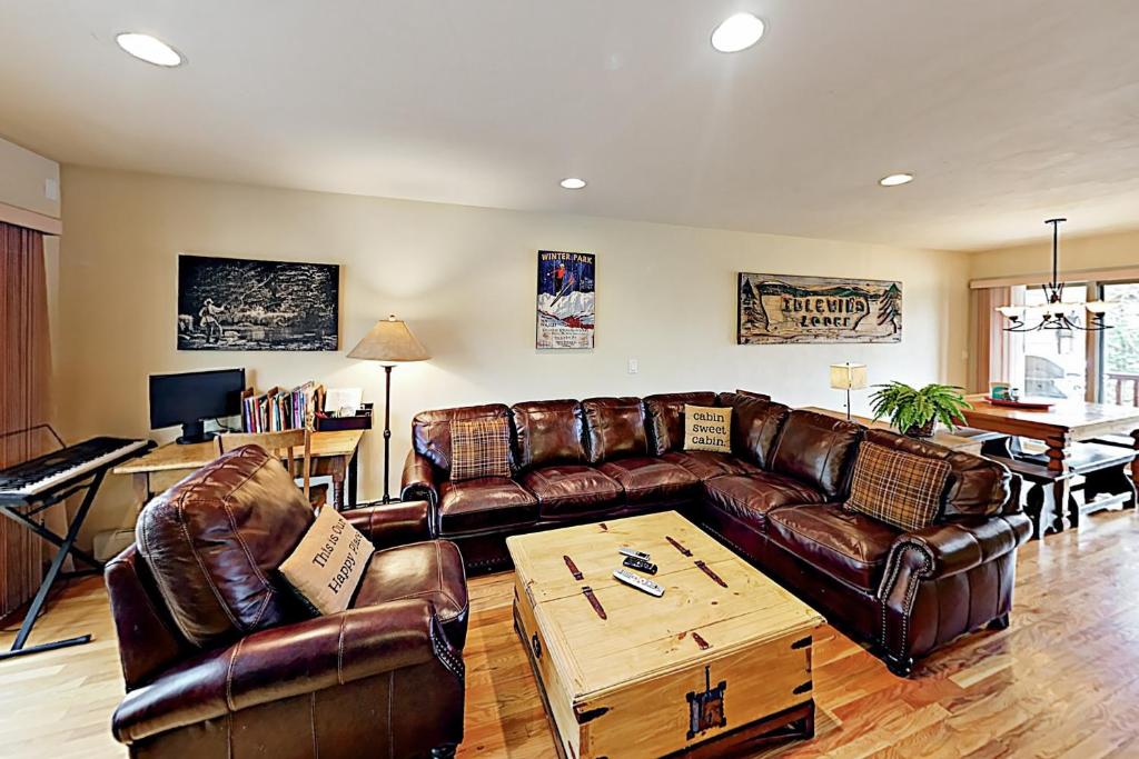 a living room with leather couches and a table at Saw Mill Station 127 in Winter Park