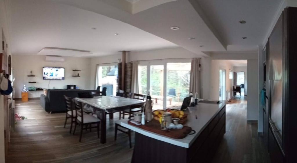 Una cocina y una sala de estar con mesa y sillas. en Balcón del Bosque, en Monte Hermoso