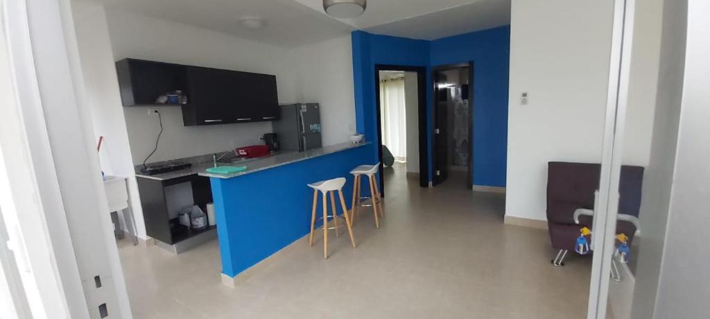 cocina con encimera azul y taburetes en una habitación en Ibiza Beach Residence’s, en Coclé