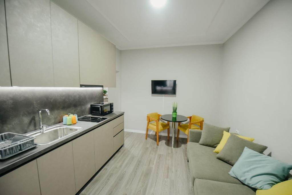 Il dispose d'une cuisine et d'un salon avec un canapé et un évier. dans l'établissement Bejart Apartment 1, à Tirana