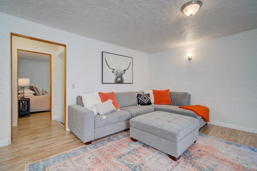sala de estar con sofá gris y almohadas de color naranja en Top floor 5th and Beall, en Bozeman