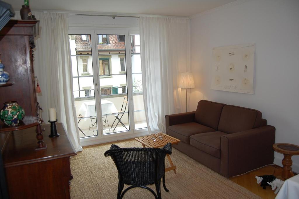 ein Wohnzimmer mit einem Sofa und einem Fenster in der Unterkunft Maison Mosgenstein in Bern