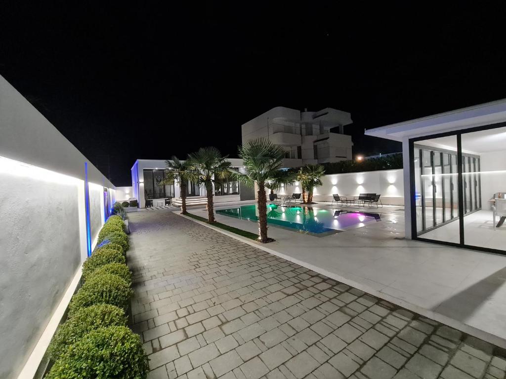 a night view of a swimming pool in a building at LT Luxury Villa in Rrushkull
