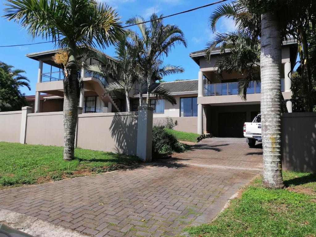 a house with palm trees and a driveway at Sanlou in Port Shepstone