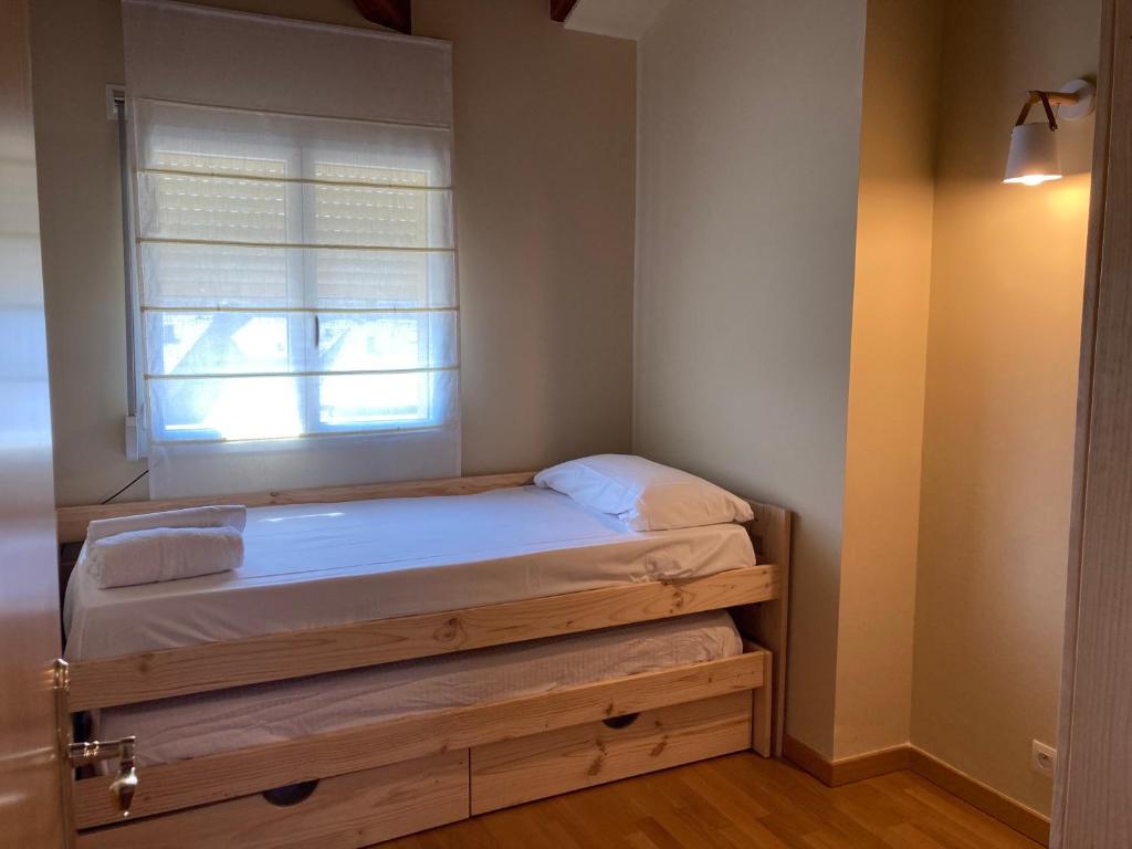 a small bedroom with a bed with a window at Casita Planes Surroca in Bourg-Madame