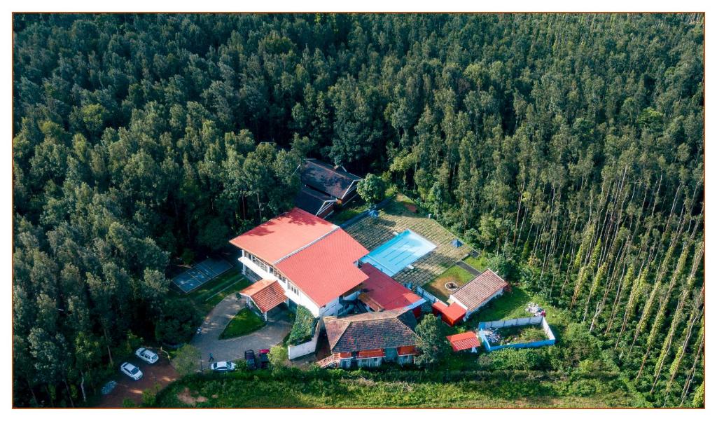 an aerial view of a house in the middle of a forest at Nexstay Coffee Grove Resort in Chikmagalūr
