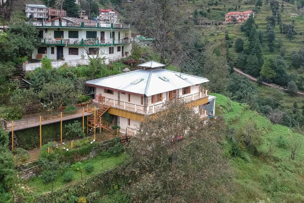 a large house on top of a hill at StayVista at Brij Valley with Indoor Games & Bonfire in Rāmgarh