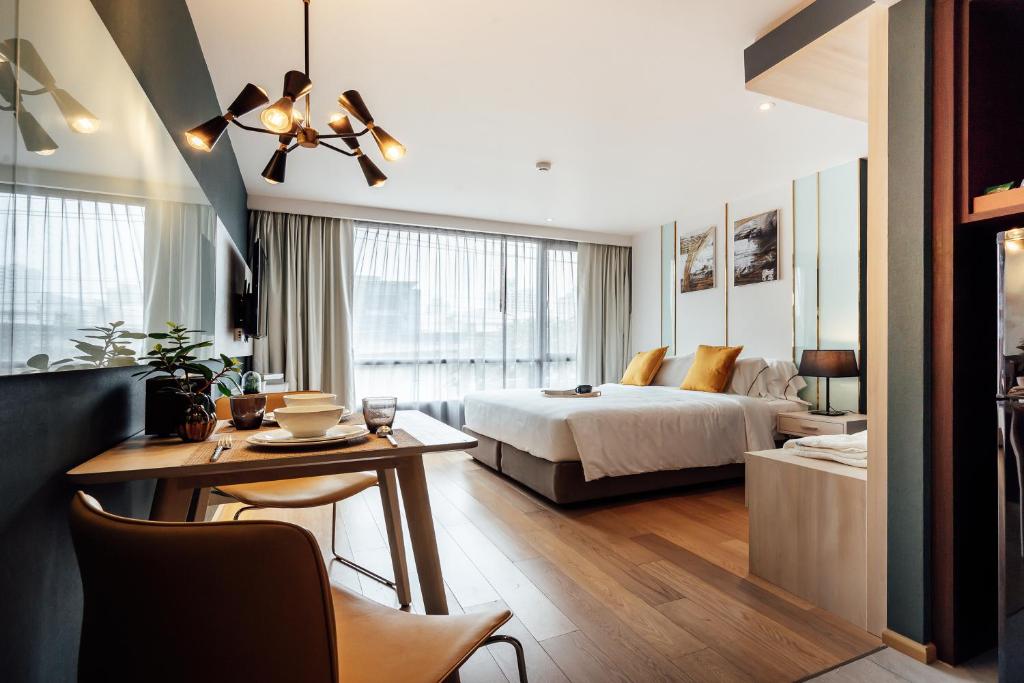una camera d'albergo con letto e tavolo e una sala da pranzo di Montana Bangkok Hotel & Residence SHA Extra Plus a Bangkok