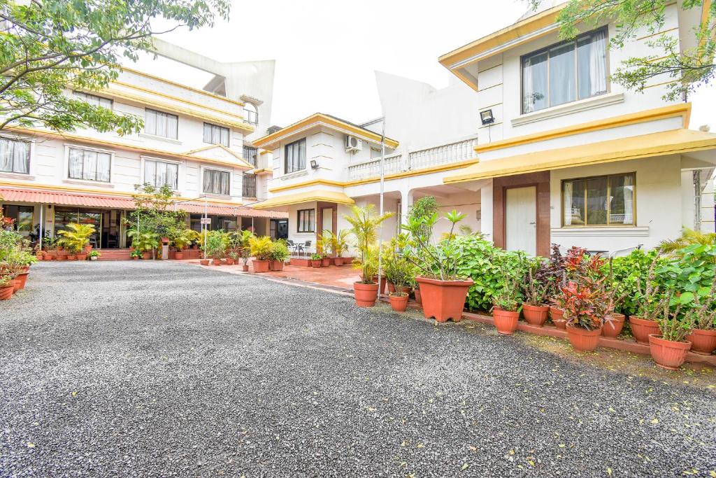 a street in front of a building with potted plants at Sereniity Resort Lonavala in Lonavala