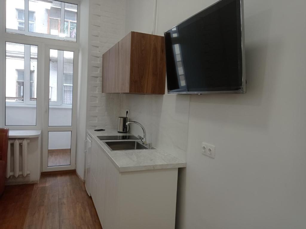 a kitchen with a sink and a tv on the wall at N.A.N. Apartments City Centre in Kyiv