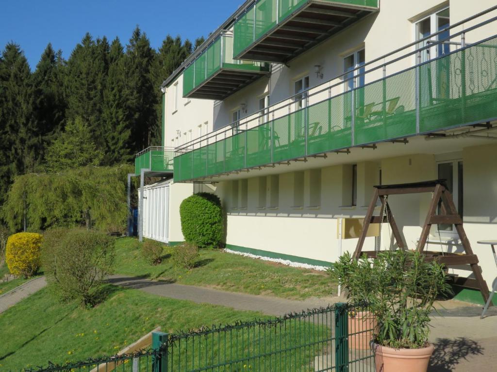 a building with green balconies on the side of it at Residenzpark Willingen Typ C in Willingen