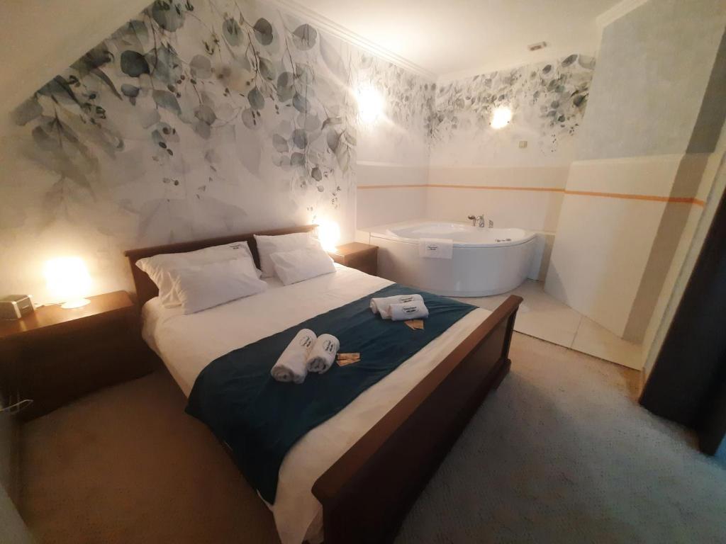 オストロウェンカにあるZielony Zakątekのベッドルーム1室(ベッド1台、バスタブ、シンク付)