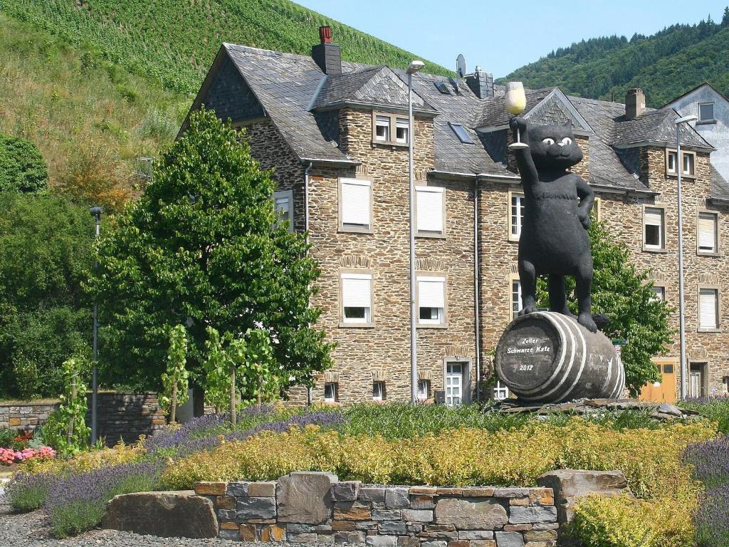 una estatua de un oso en un barril frente a un edificio en Mosel Ferienhaus Kleine Merle en Zell an der Mosel