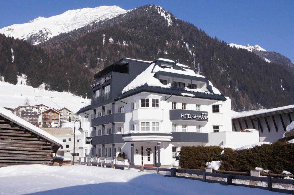 イシュグルにあるHotel Germaniaの山を背景にしたホテルの建物