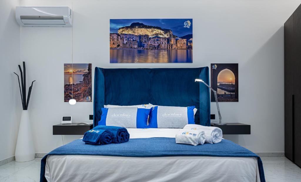 Un dormitorio con una cama azul con toallas. en BM SUITES CEFALU, en Cefalú
