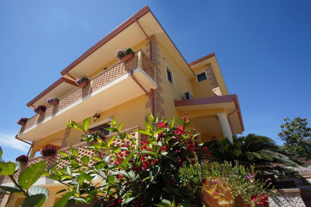 Una casa amarilla con plantas delante. en B&B Villa Maria, en Catanzaro