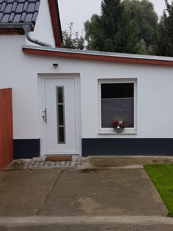 Casa blanca con ventana y puerta en Ferienwohnung Schmenkel, en Angermünde