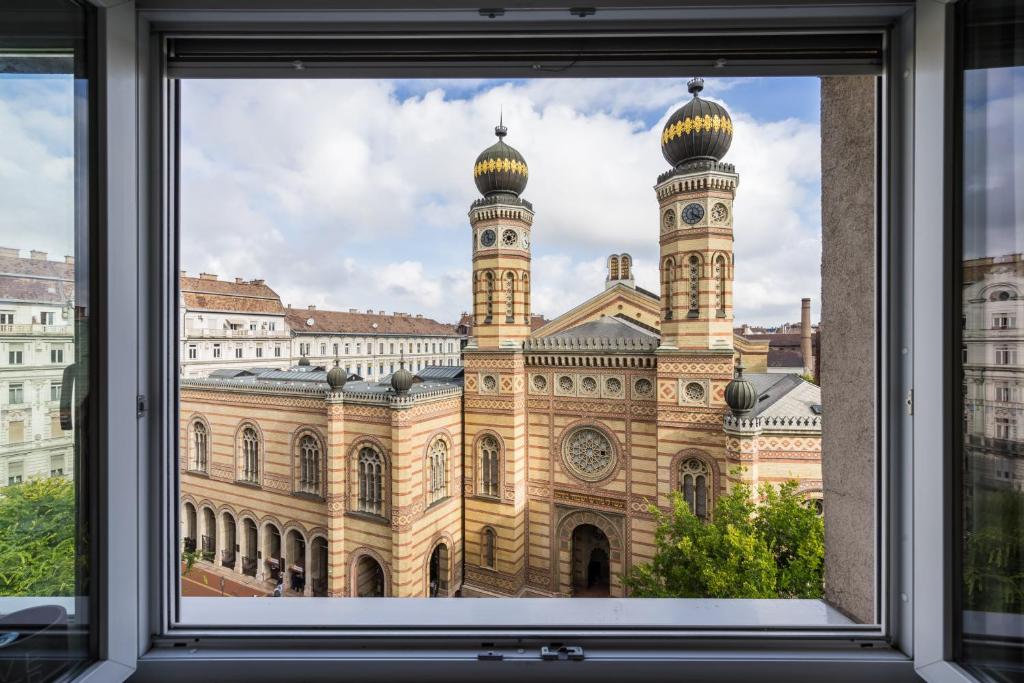 a window view of a large building with a clock tower at Breathless view Synagogue elegant apartment FREE PARKING RESERVATION NEEDED in Budapest