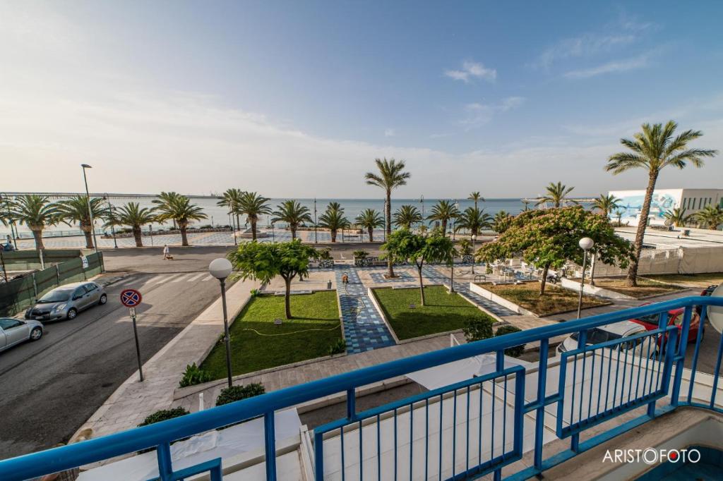 een balkon met uitzicht op een straat en de oceaan bij B&B Una Rotonda sul mare in Manfredonia