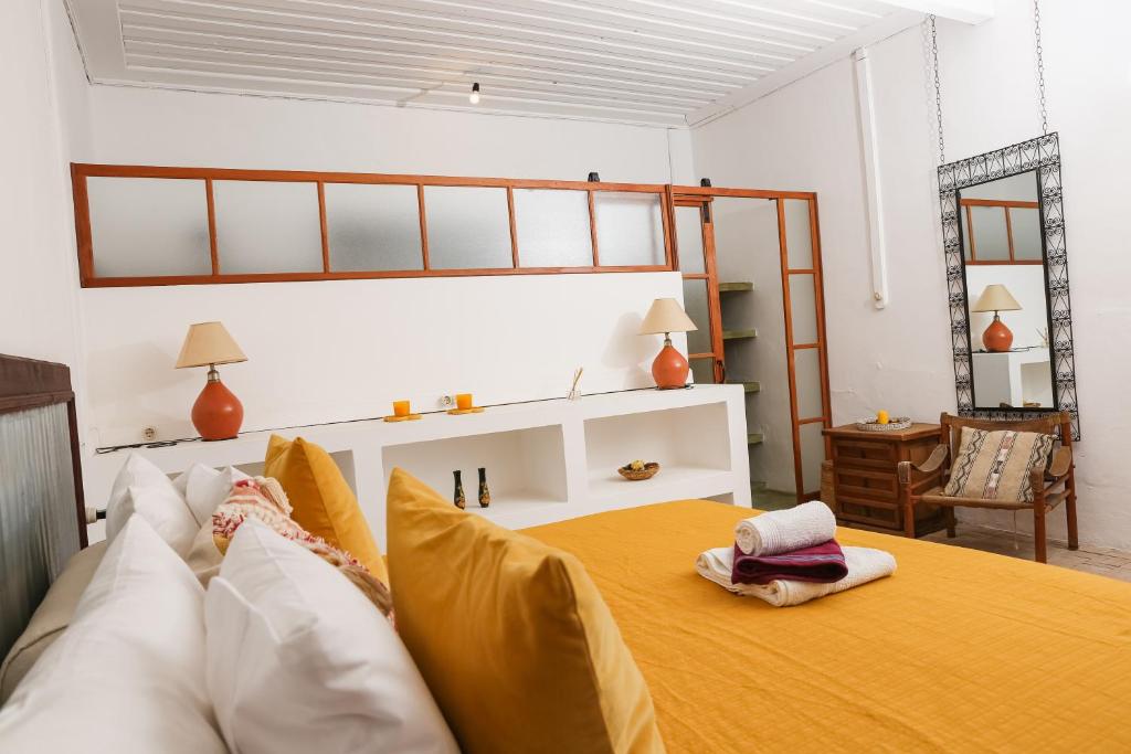 1 dormitorio con 1 cama grande con sábanas y almohadas amarillas en Casa Colonial Koenig, en São Filipe