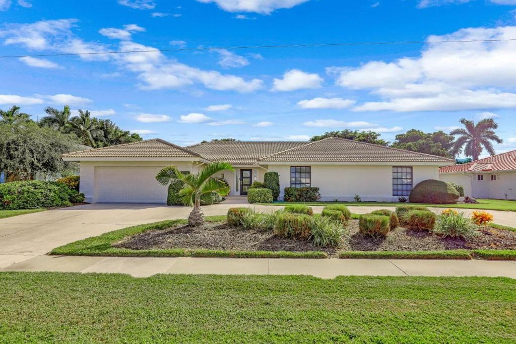 a house with a palm tree in the front yard at 216 Shadowridge Court in Marco Island