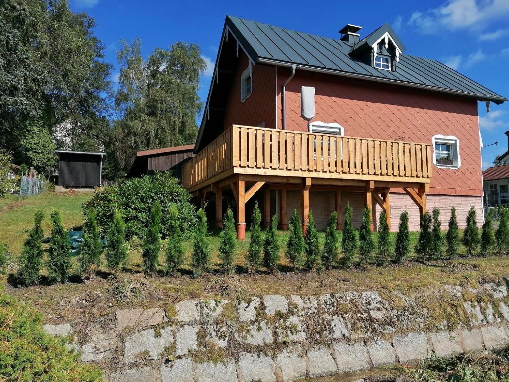 une maison avec quelques arbres de Noël devant elle dans l'établissement Fichtelfeeling, à Fichtelberg