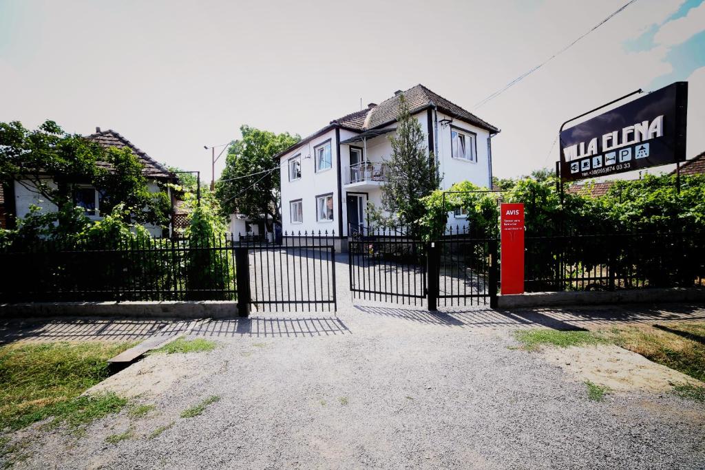 a white house with a red telephone box in front of a gate at Villa Elena in Yanoshi