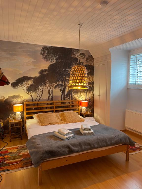 a bedroom with a large bed with a painting on the wall at Zee Vakantievilla Begijnhof 5 De Haan in Nieuwmunster