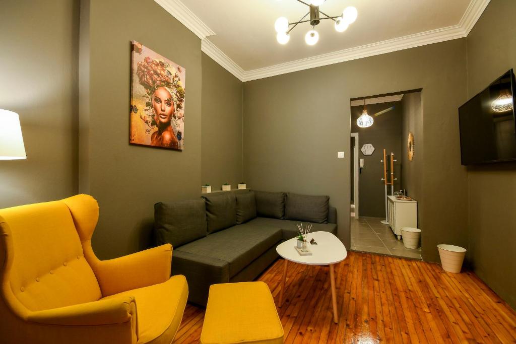 a living room with a green couch and yellow chairs at Thessaloniki Center Superior Apartment in Thessaloniki