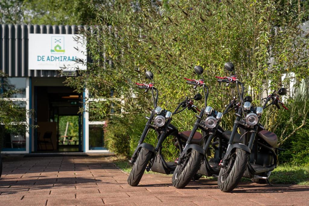 twee motorfietsen geparkeerd voor een gebouw bij de Admiraal in Den Helder