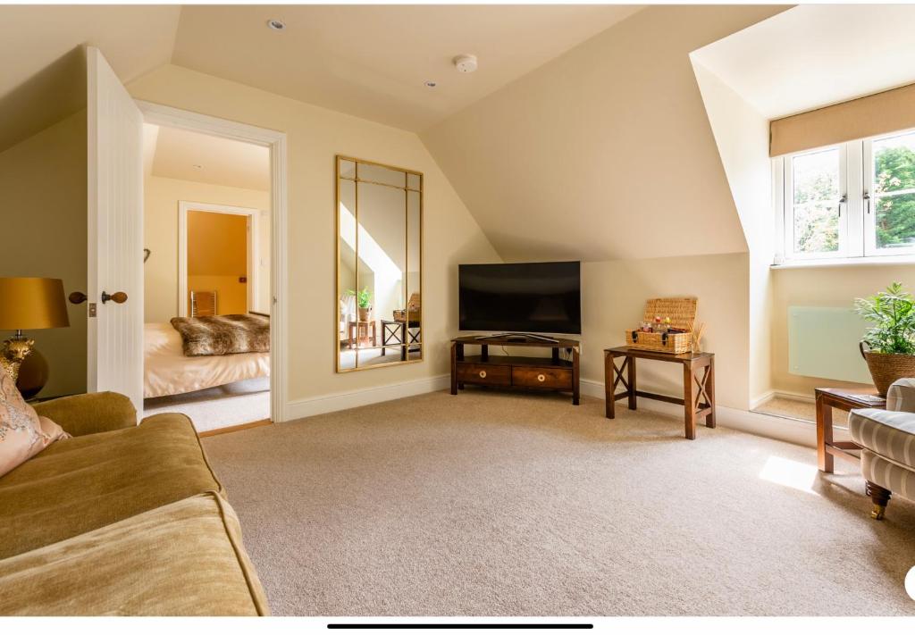 a living room with a couch and a television at The Cartlodge in Wickham Bishops