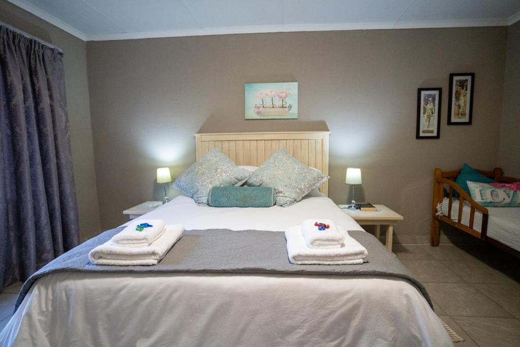 ein Schlafzimmer mit einem Bett mit Handtüchern darauf in der Unterkunft Misty Morn Cottages in Muldersdrift