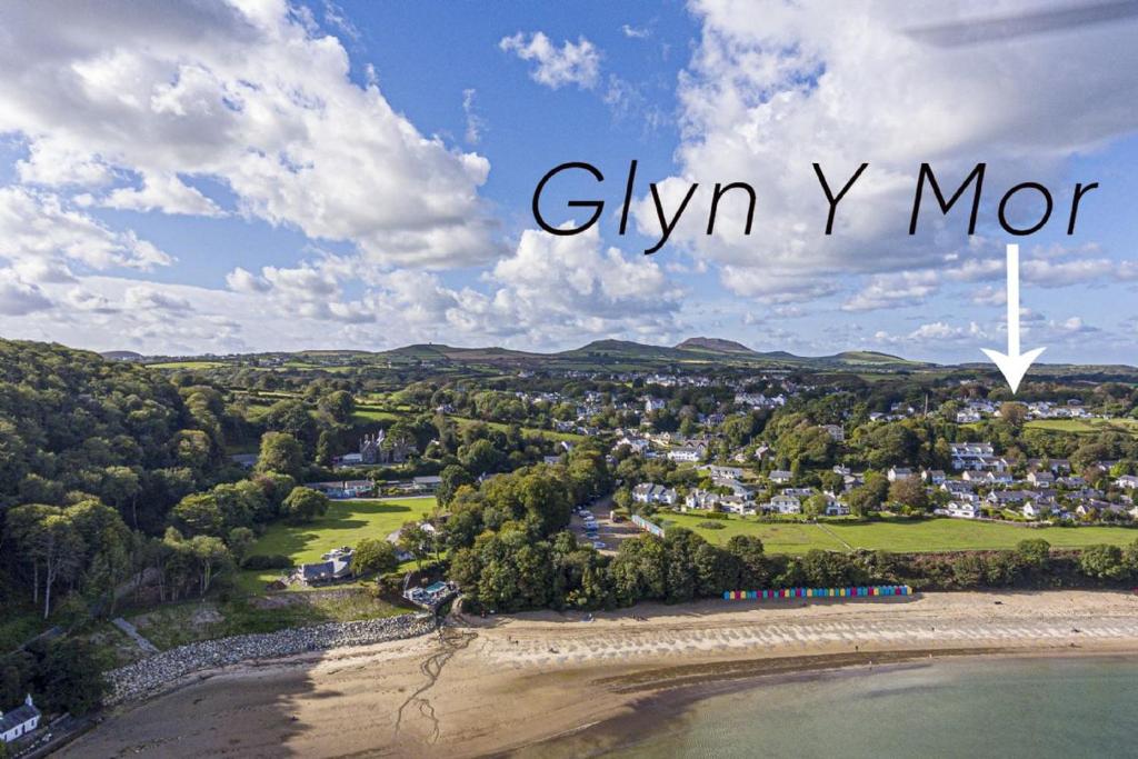 een luchtzicht op een stad met een witte windmolen bij Glyn-y-Mor - Llanbedrog in Llanbedrog