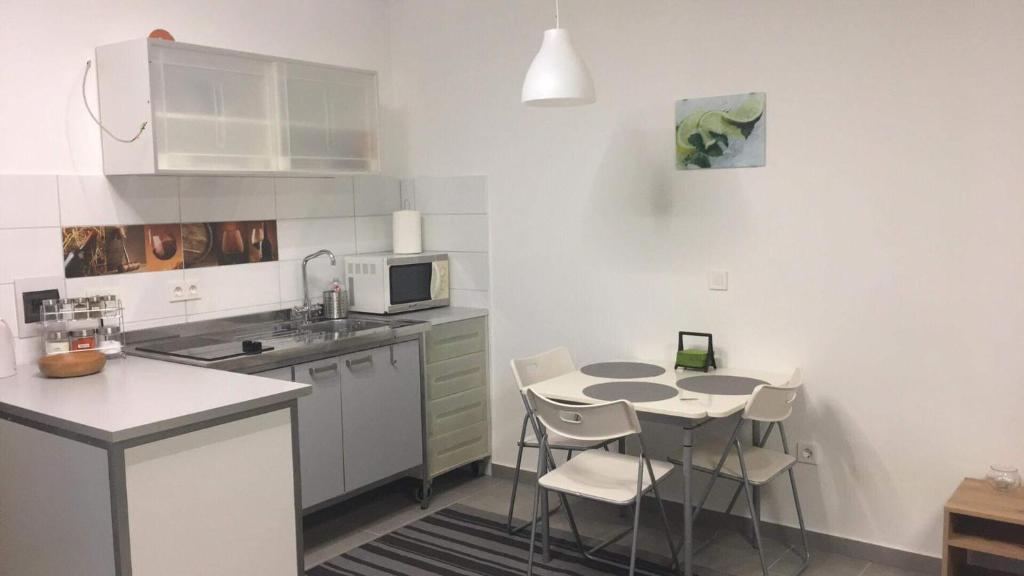 a small kitchen with a table and chairs in it at Cuki Apartmanok in Dombóvár