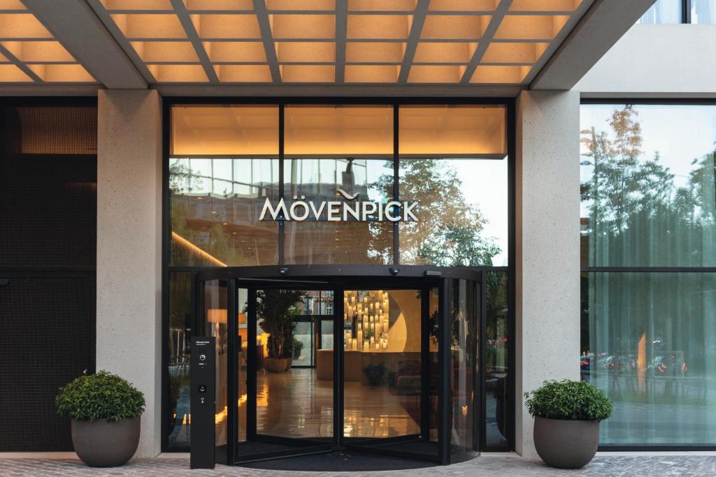 a building with a revolving door with a sign on it at Mövenpick Hotel Basel in Basel
