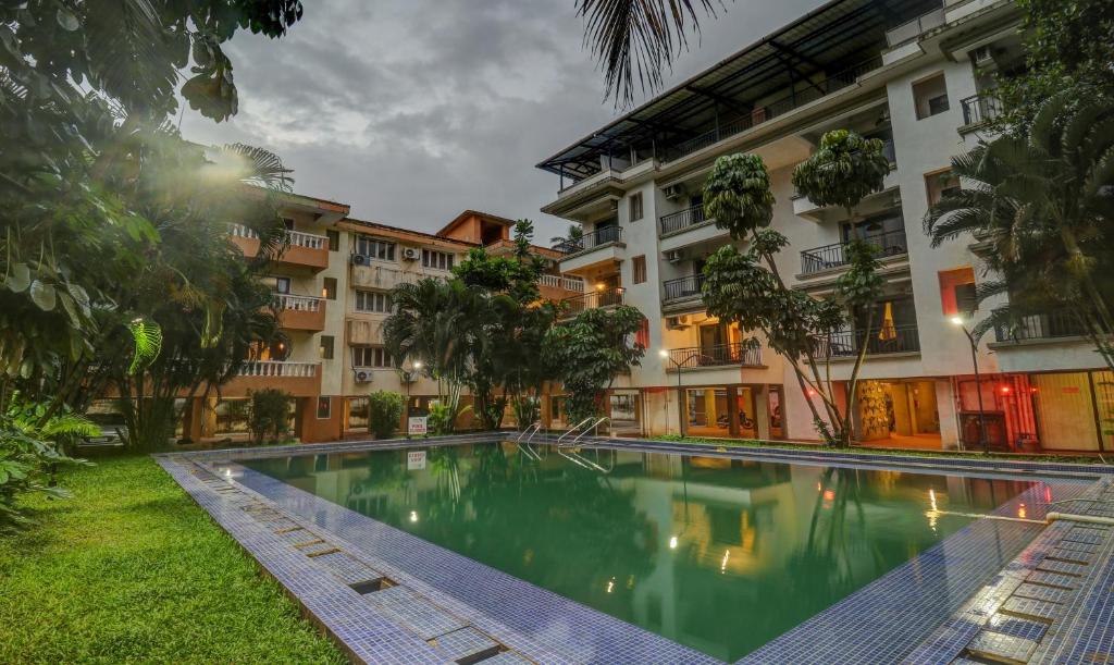 a swimming pool in front of a building at Treebo Aquamarine Arpora With Pool in Arpora