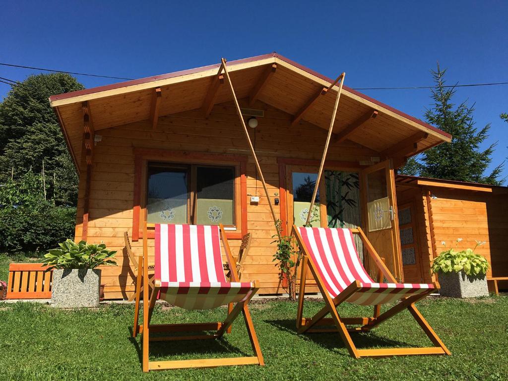 dwa bujane krzesła przed kabiną w obiekcie Lookout Resort tiny houses w mieście Rovte