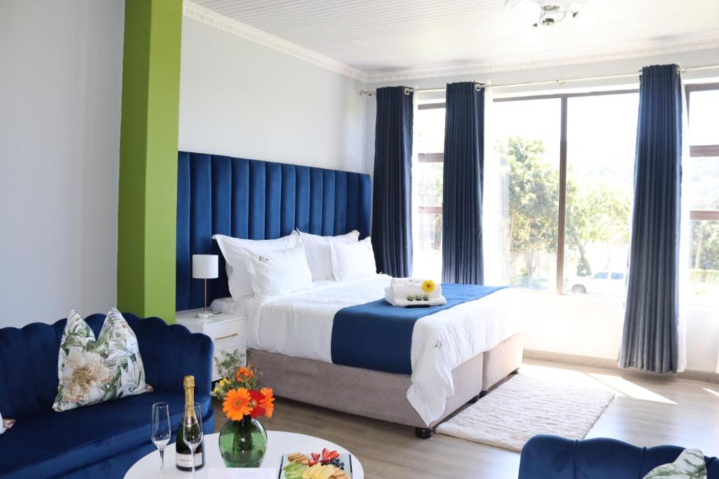Un dormitorio con una cama azul y blanca y un sofá en Uzuri Lifestyle en Port Saint Johnʼs
