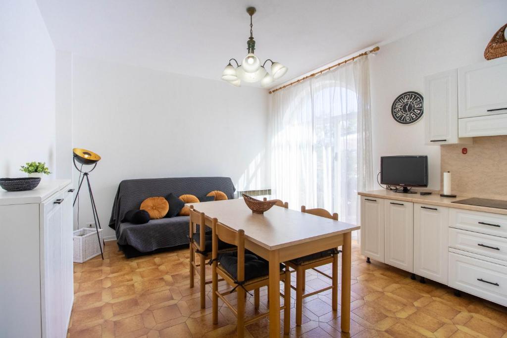 uma cozinha e sala de estar com uma mesa e um sofá em Luminoso appartamento con ampia terrazza em San Bartolomeo al Mare