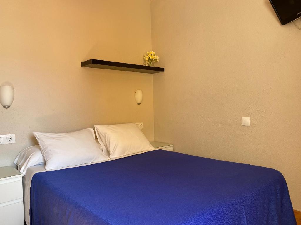A bed or beds in a room at Hostal Moscatel