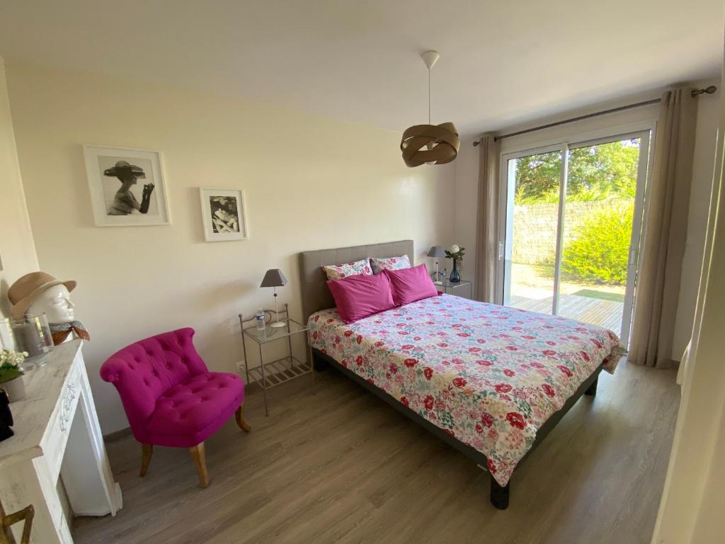 una camera con letto rosa e sedia rosa di Le Clos des Chênes a Challans