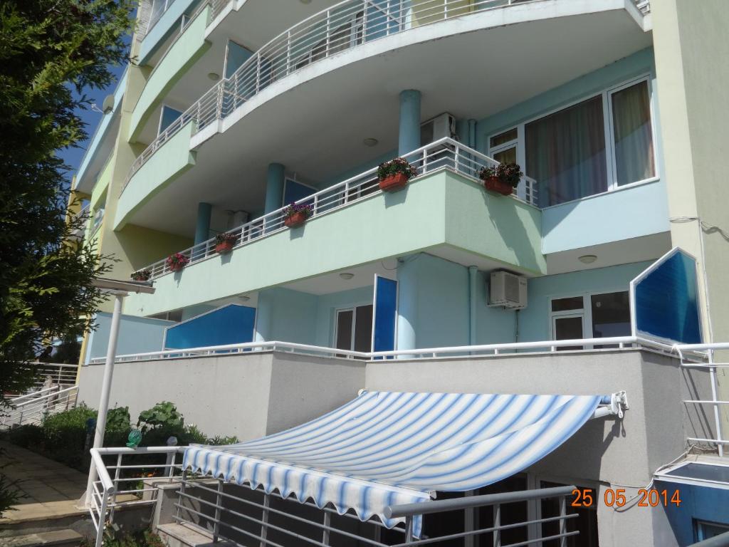un edificio de apartamentos con toldos y balcón en Evridika Apartments, en Nesebar