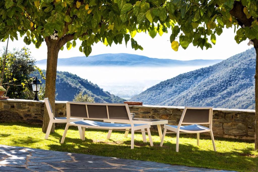 two chairs and a table with a view of mountains at El Porxo de Can Baixeres in Montseny