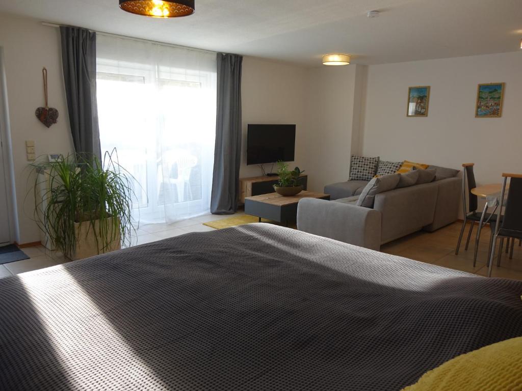 GaukönigshofenにあるExclusive kuschelige Wohnung im Herzen FrankensEuropaのベッドルーム1室(ベッド1台付)、リビングルームが備わります。