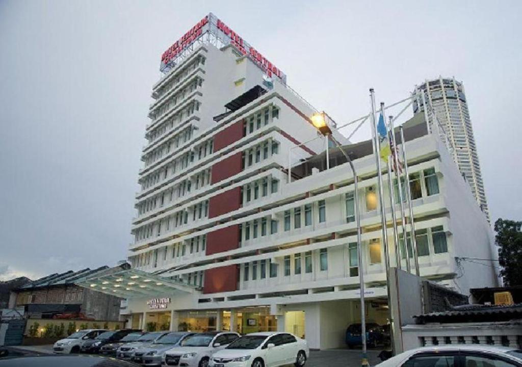 a large building with cars parked in a parking lot at Hotel Sentral Georgetown @ City Centre in George Town